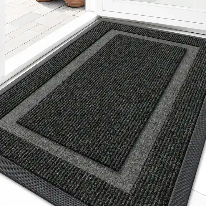 Black and gray framed border entryway mat with ribbed texture at front door entrance