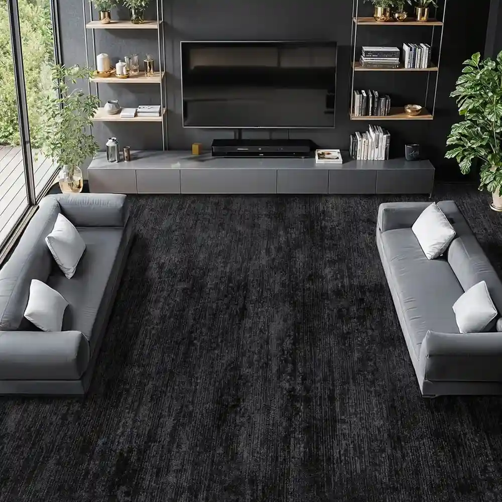 Large black textured area rug in modern living room with gray sofas and dark walls