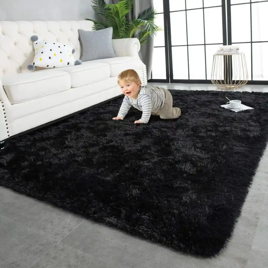 Happy baby crawling on large black shag area rug in modern living room with white tufted sofa