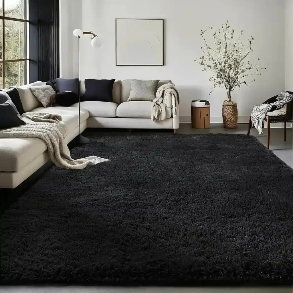 Large black shag area rug in modern living room with white sectional sofa and navy pillows