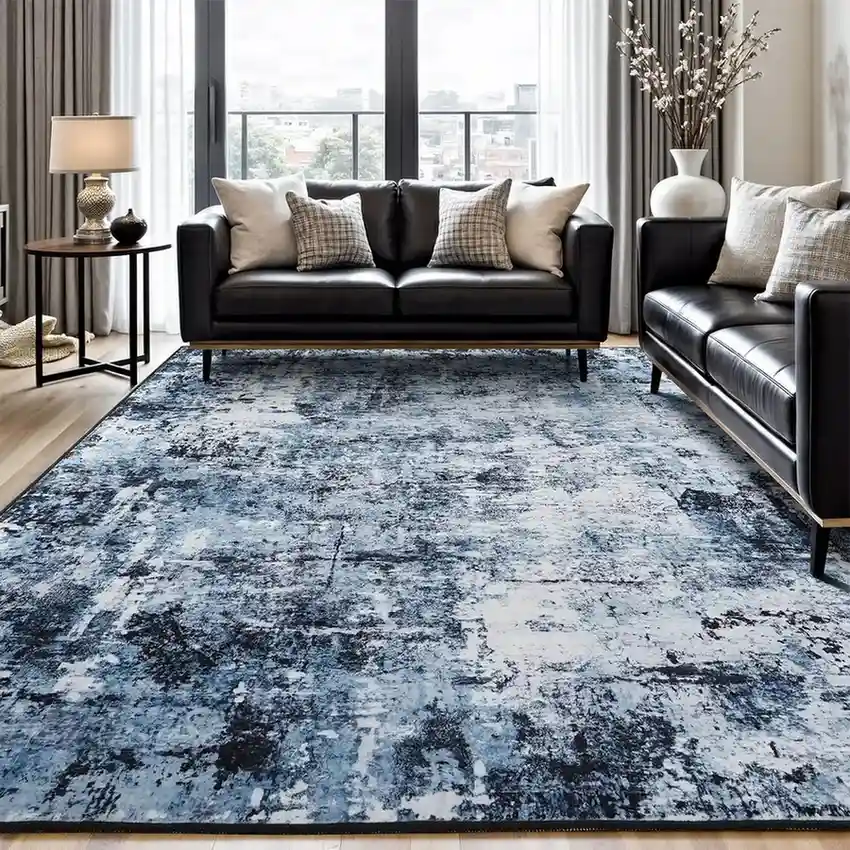 Blue and gray abstract area rug in modern living room with black leather sofas