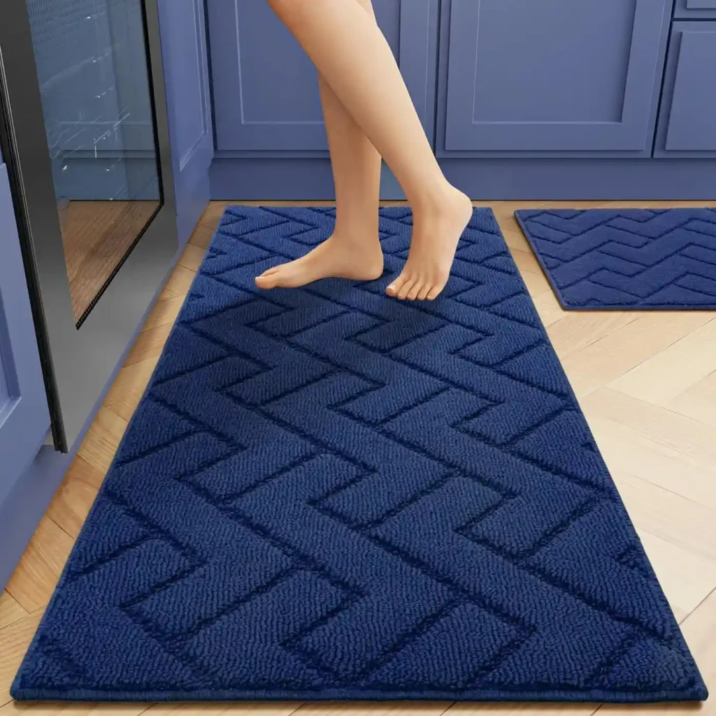 Navy blue chevron patterned bath mat set in bathroom with blue cabinets
