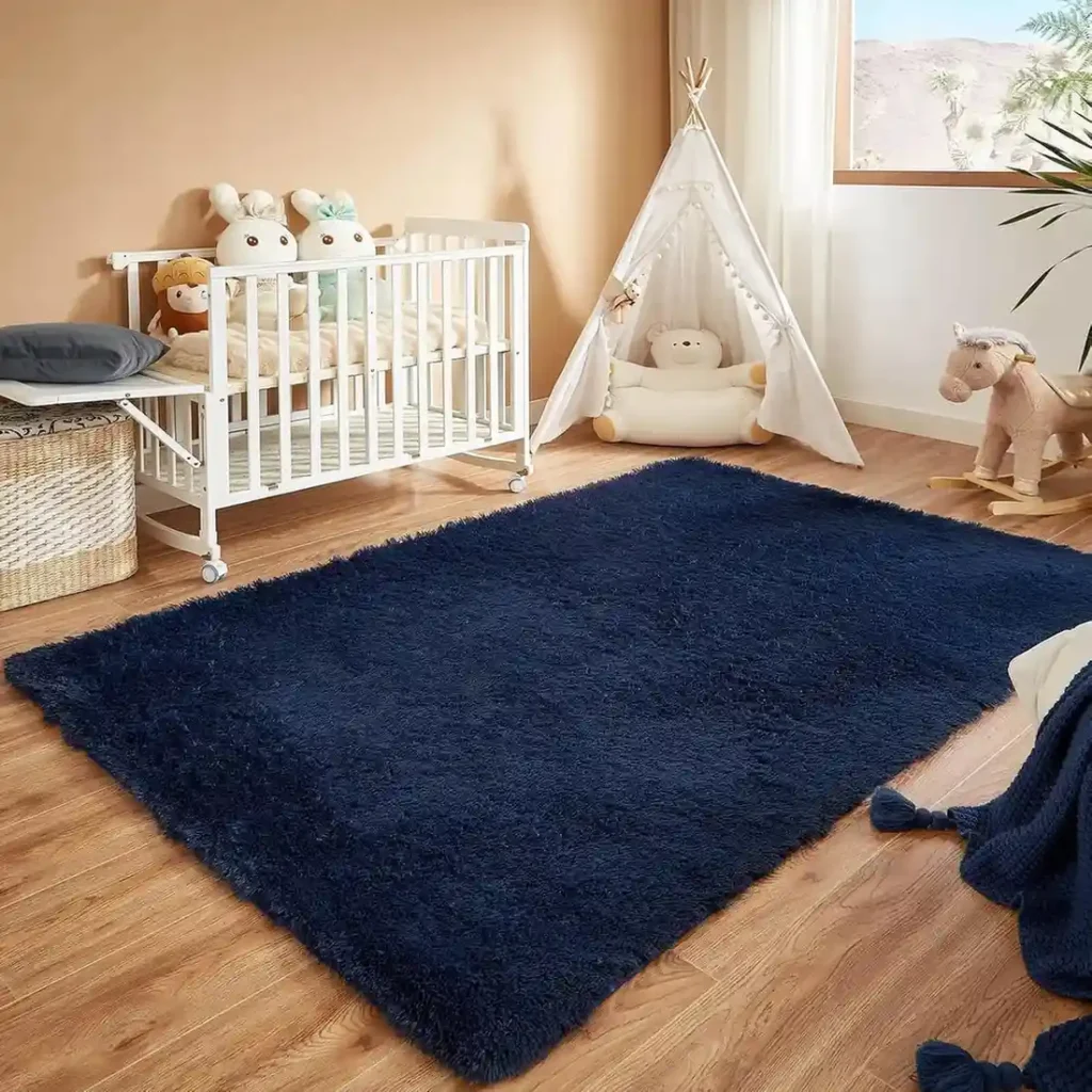 Navy blue plush shag rug in nursery with white crib and teepee