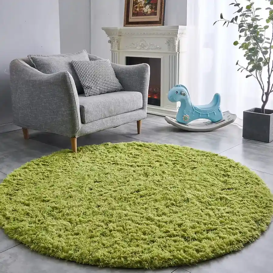 Round lime green shag area rug in living room with gray armchair and white fireplace.