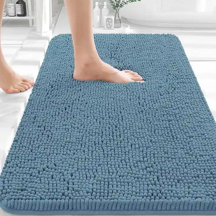 Soft blue chenille bath mat with shaggy texture in white bathroom