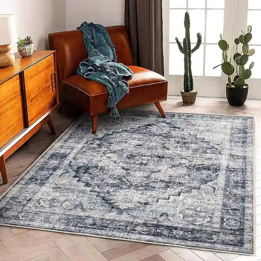 Vintage distressed blue gray geometric area rug in modern living room with leather chair and wooden furniture